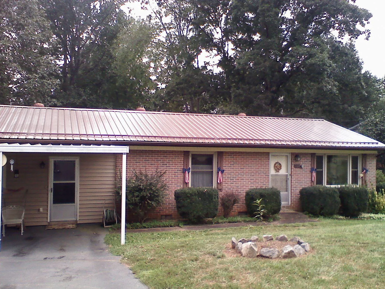 Bronze metal roof and carport on a brick ranch home — Roof Repair work by our crew in Gilbertville